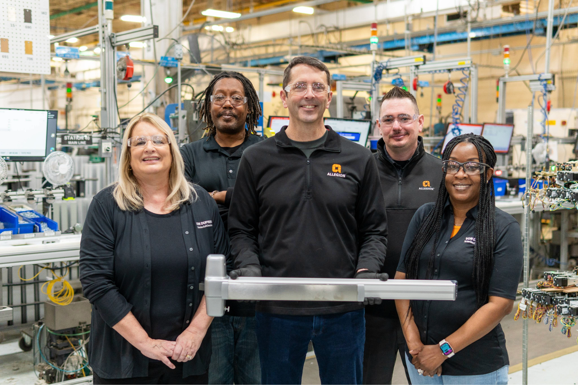 Allegion employees display a Von Duprin exit device.