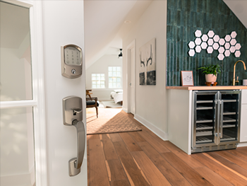 A Schlage lock is seen on a door entering a home